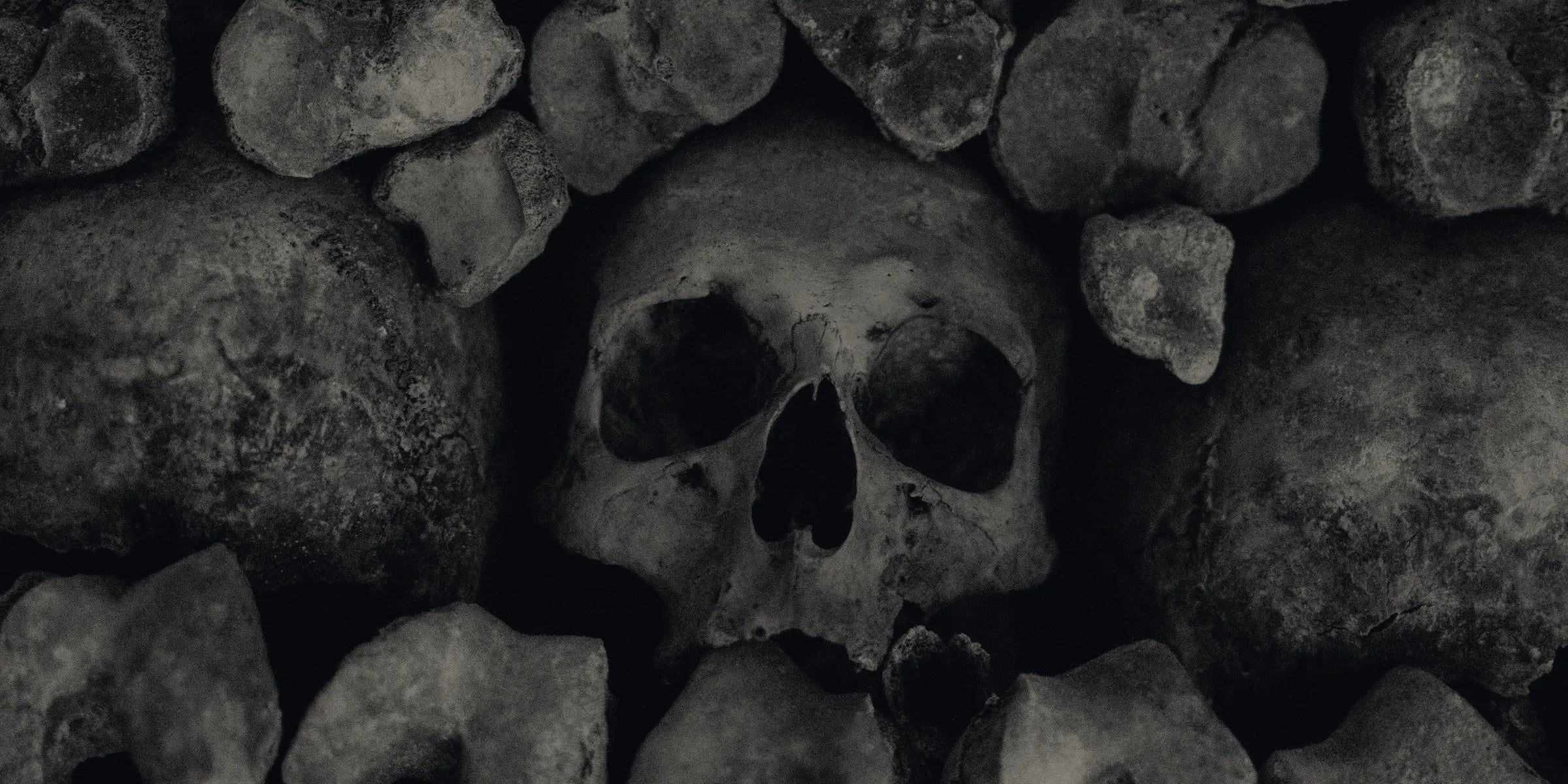 Wall of stacked skulls in the dark